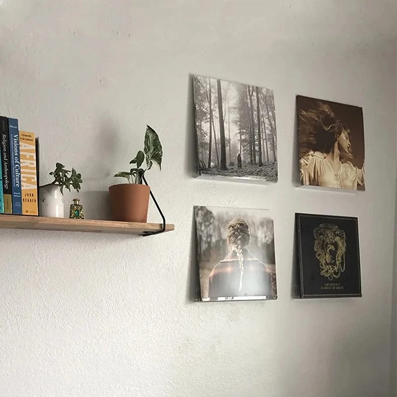 4 clear acrylic record shelves on a wall next to a wooden shelf